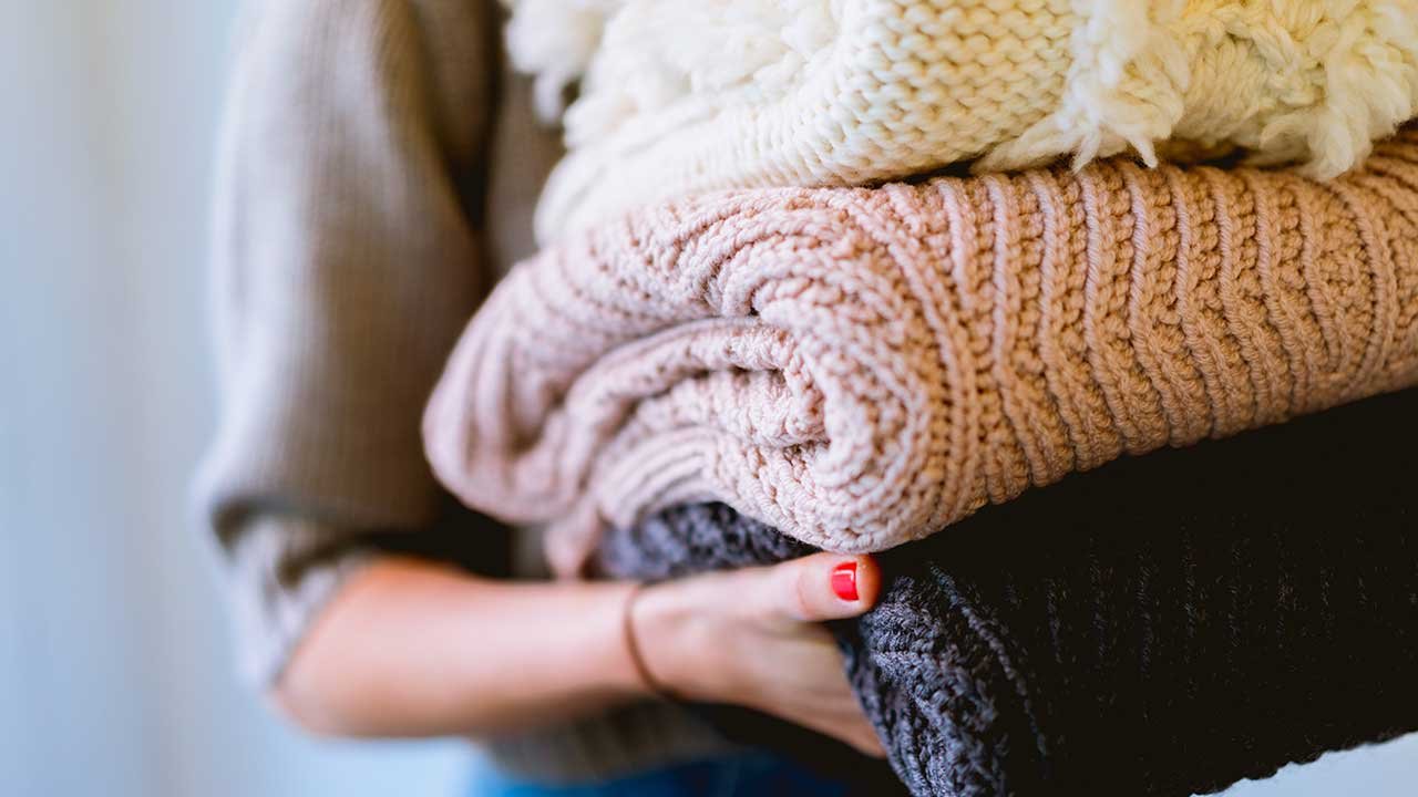 Mujer llevando ropa vieja a donar