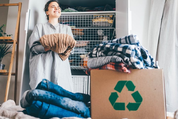 Mujer feliz reciclando ropa