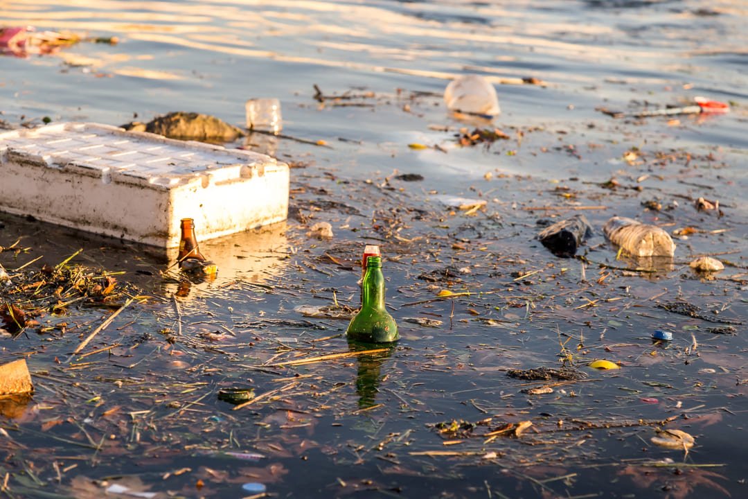 plasticos y botellas contaminando agua